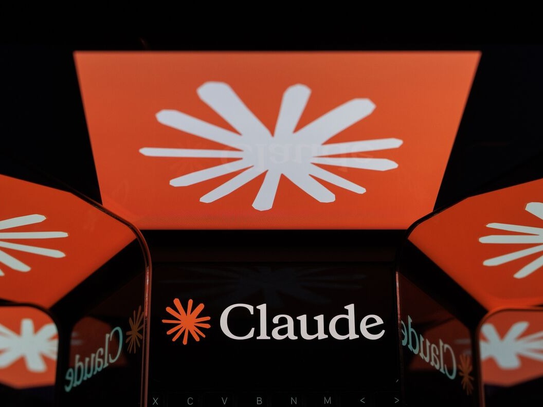 彭博报道配图，画面为一组显示 Claude 标识的屏幕装置