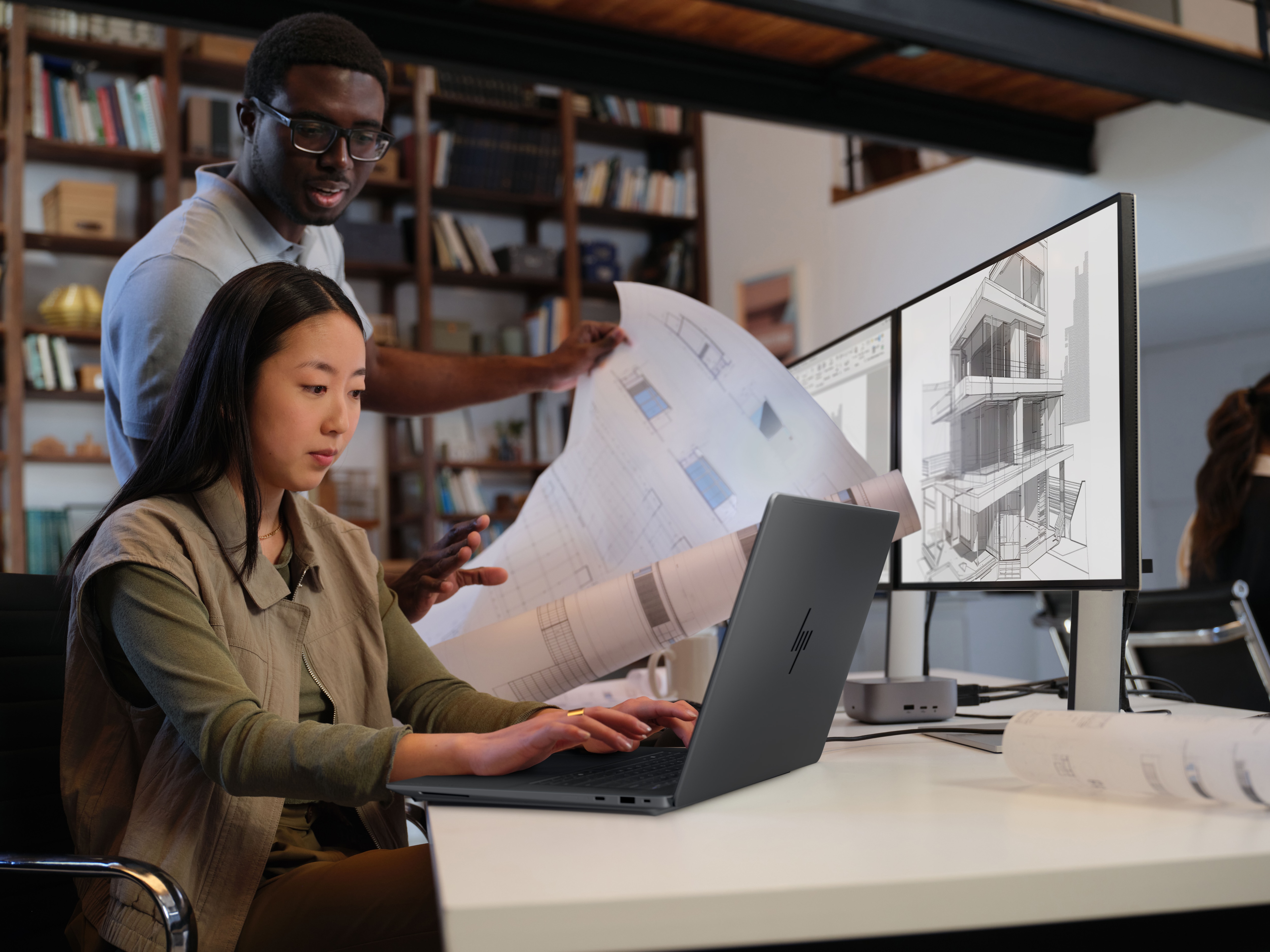 HP 新闻稿配图：ZBook Ultra 16 与建筑立面图纸、摊开的蓝图同框的办公场景
