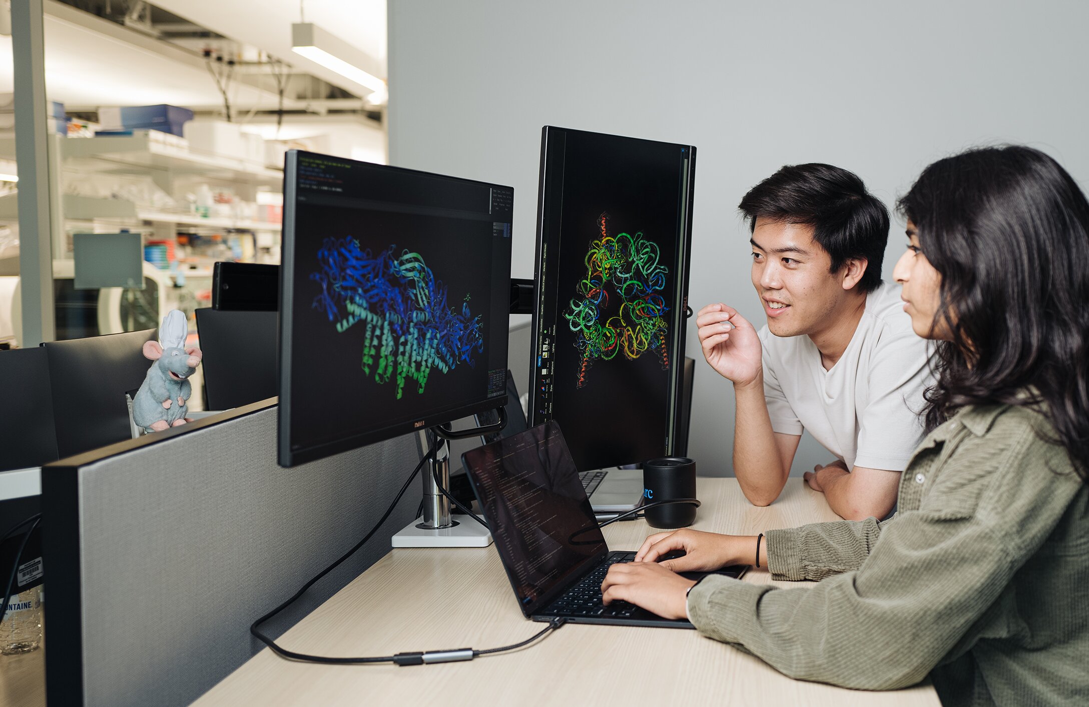 Brian Hie 与 Aditi Merchant 查看 Evo 2 生成的蛋白质结构。图片来源：Andrew Brodhead / Stanford University