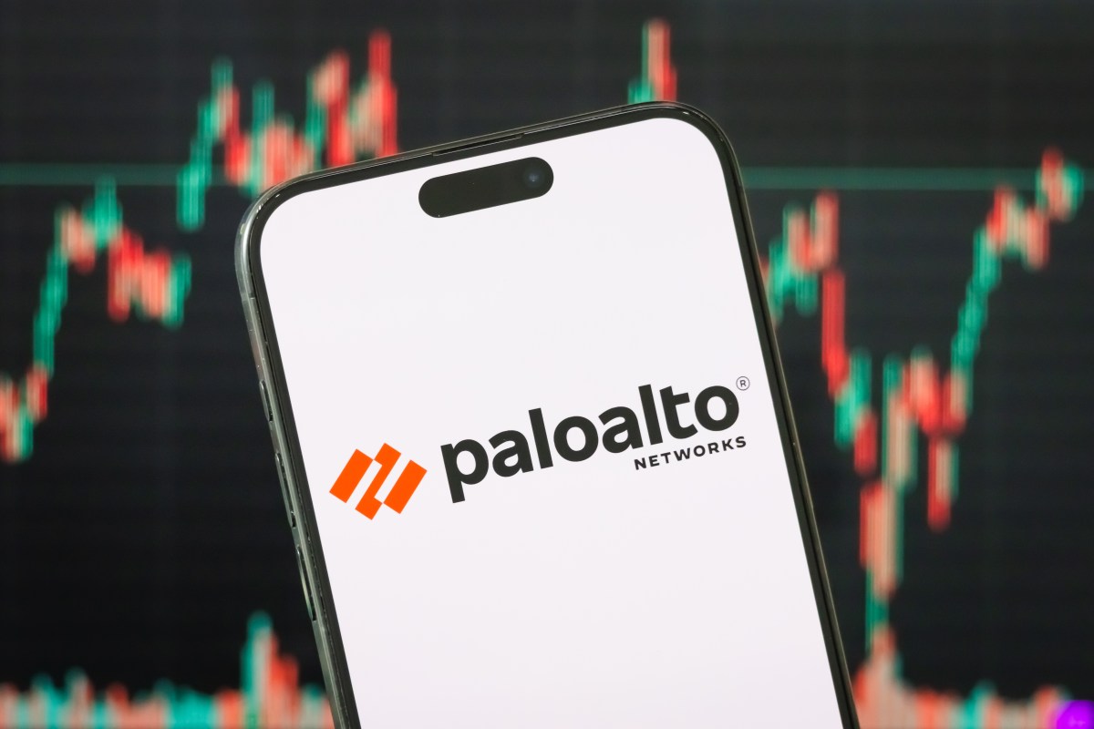 Palo Alto Networks 标识显示在倾斜的手机屏幕上，背景为红绿行情图表（Cheng Xin/Getty Images）