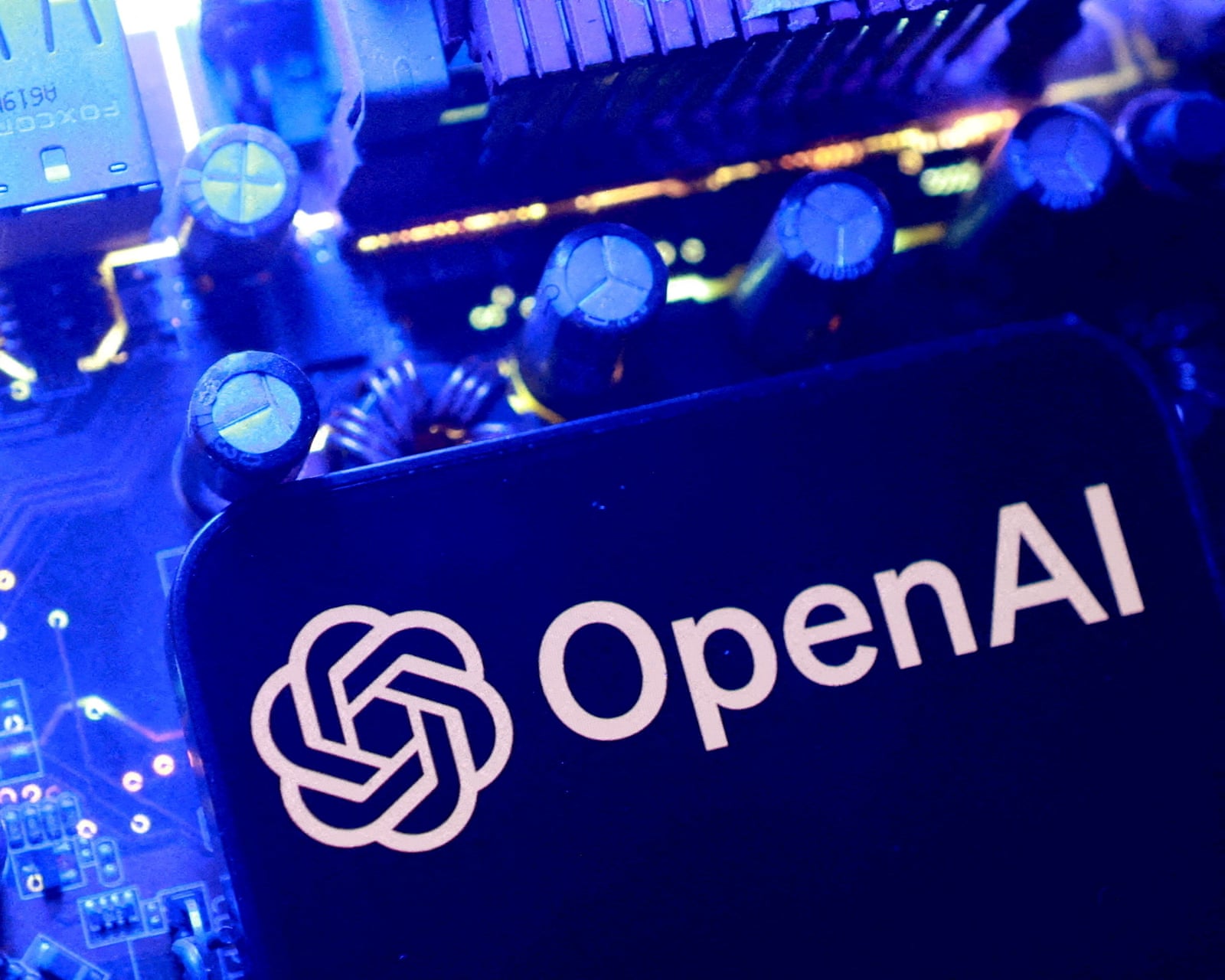 路透社拍摄的 OpenAI 标志芯片特写，The Guardian 报道配图