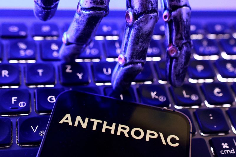 路透社报道配图：手机屏幕上显示 Anthropic 字样，一只机械手悬停其上