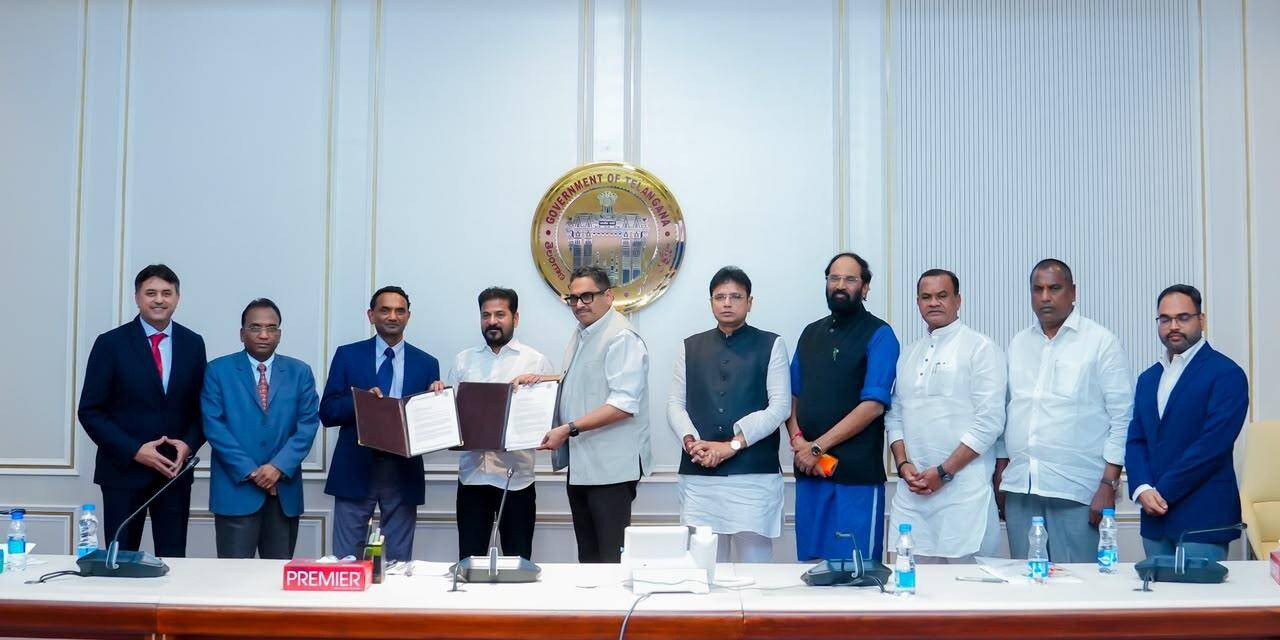 HyperVault 与 Telangana 邦政府在海得拉巴交换谅解备忘录文件，背景墙上为 Telangana 邦徽