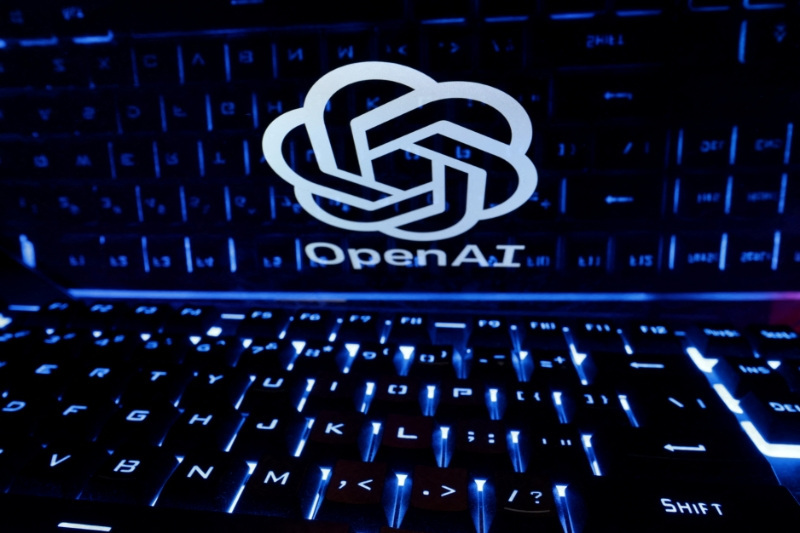 键盘后方的屏幕上显示着 OpenAI 标志