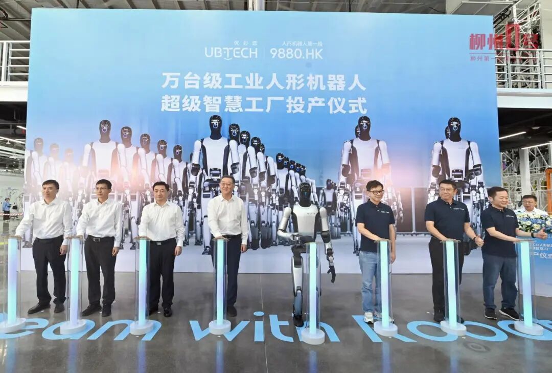 投产仪式现场，嘉宾与一台人形机器人共同启动投产装置