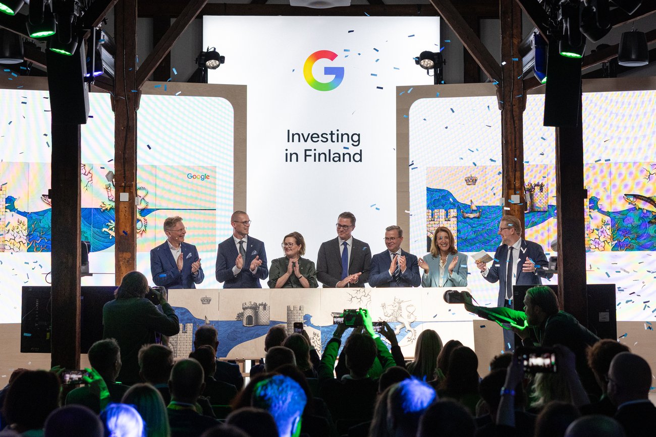 谷歌芬兰投资公告活动现场：背景屏幕显示“Investing in Finland”与谷歌标识