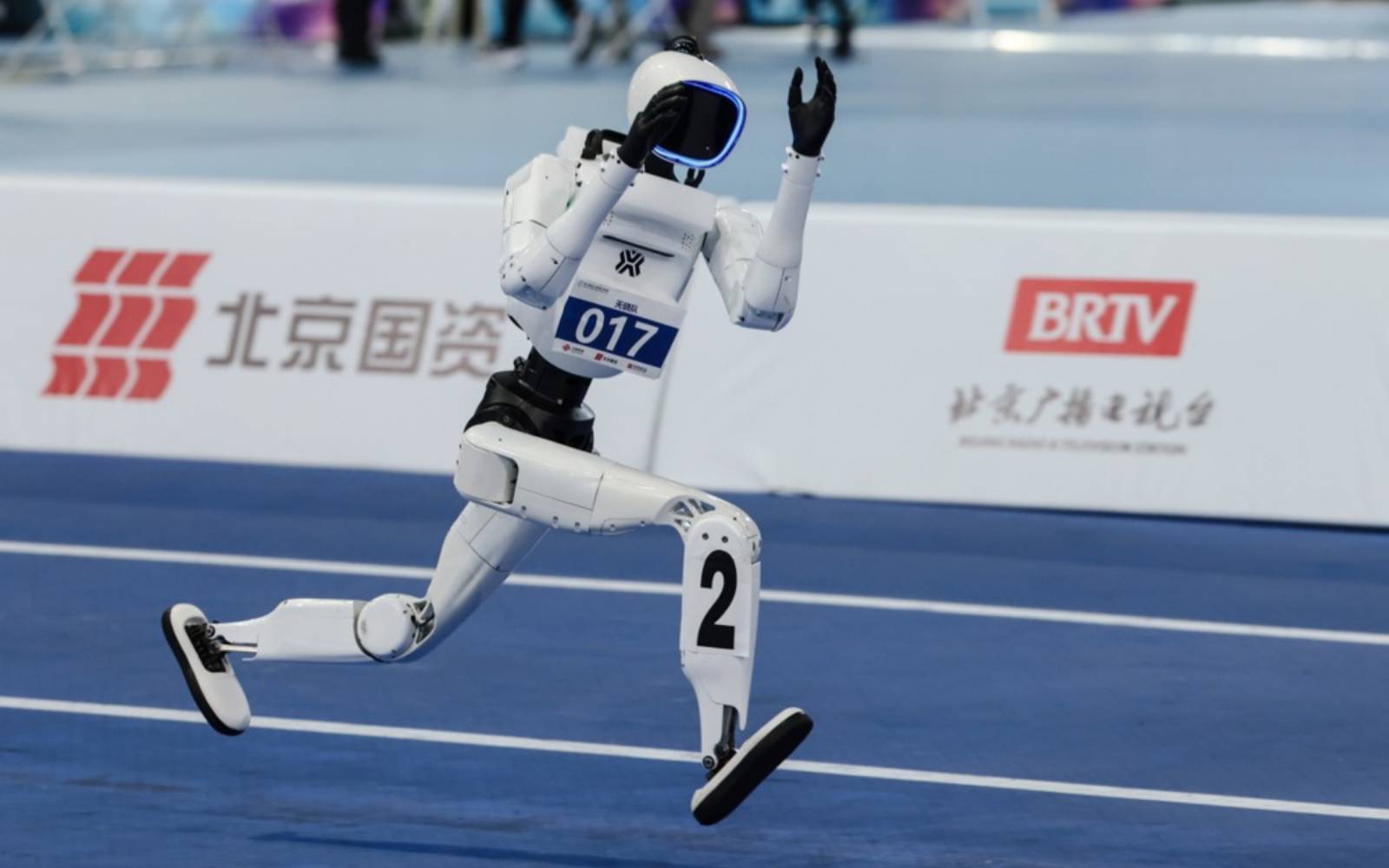 人形机器人在北京国家速滑馆举行的 2026 年世界人形机器人运动会百米赛中奔跑