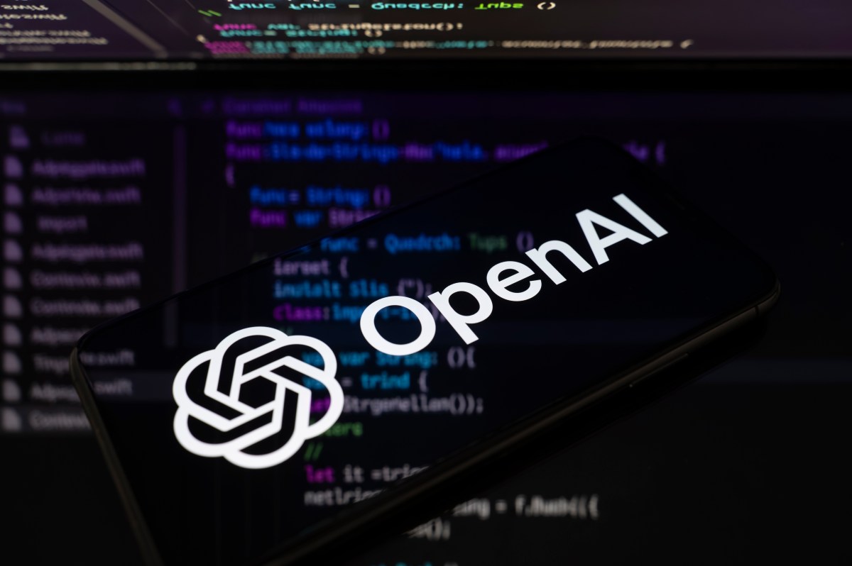显示 OpenAI 标志的手机屏幕，背景是模糊的代码编辑器