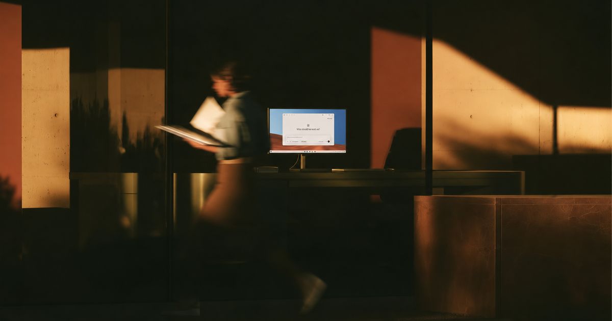 Perplexity 官方博客中 Windows 版公告的配图：办公室里一台亮着 Perplexity 界面的显示器，一名行人从旁边经过
