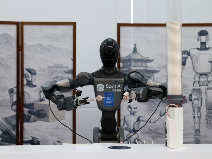 Spirit AI 的 Moz1 轮式人形机器人在 2026 年中关村论坛上演示模拟咖啡馆场景，递送冰糖葫芦（路透社图片，2026 年 3 月 25 日摄）